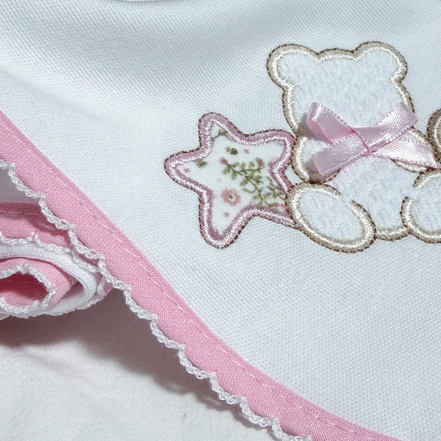 Pormenor de fralda com motivo ursinho entre estrela e coração rosa