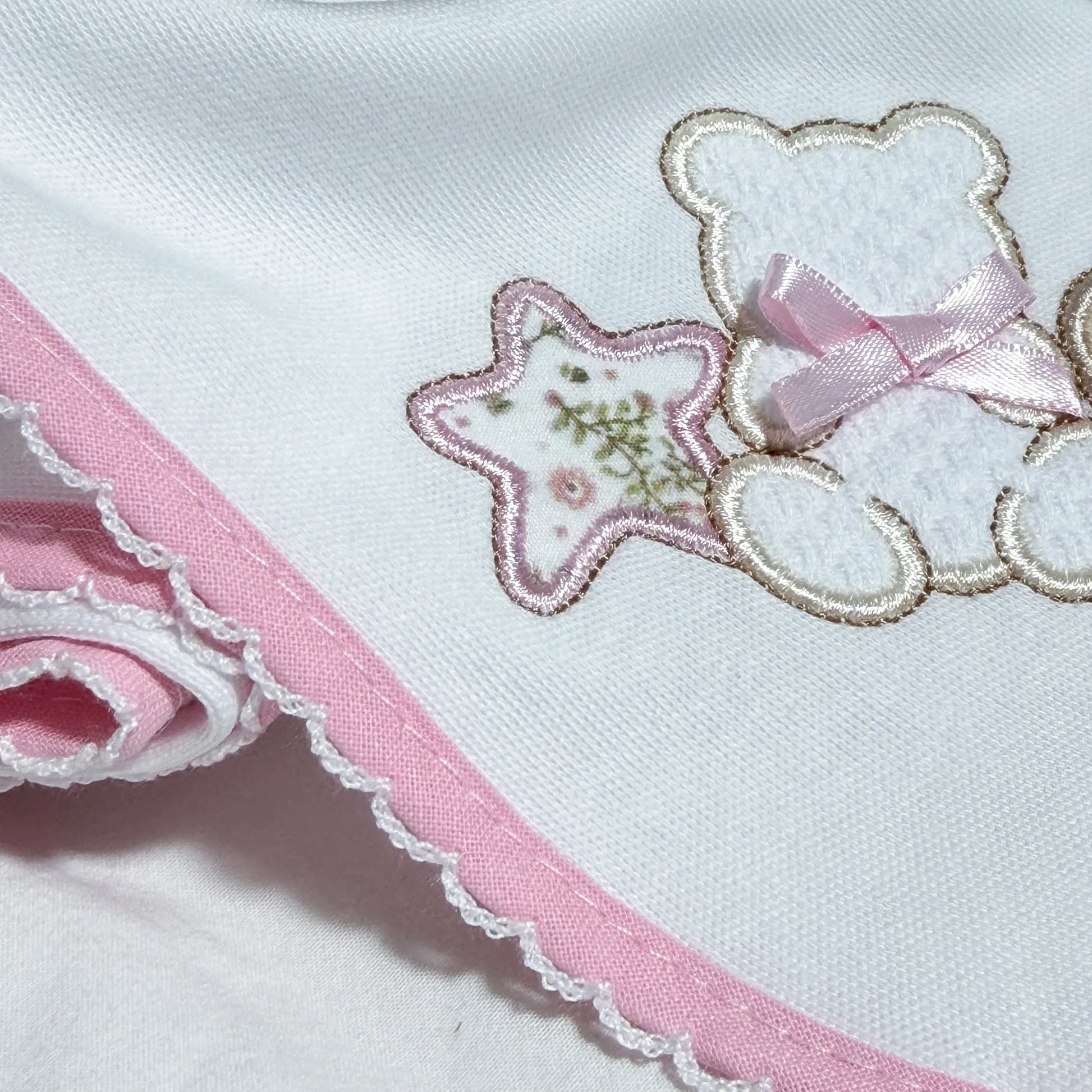 Pormenor de fralda com motivo ursinho entre estrela e coração rosa