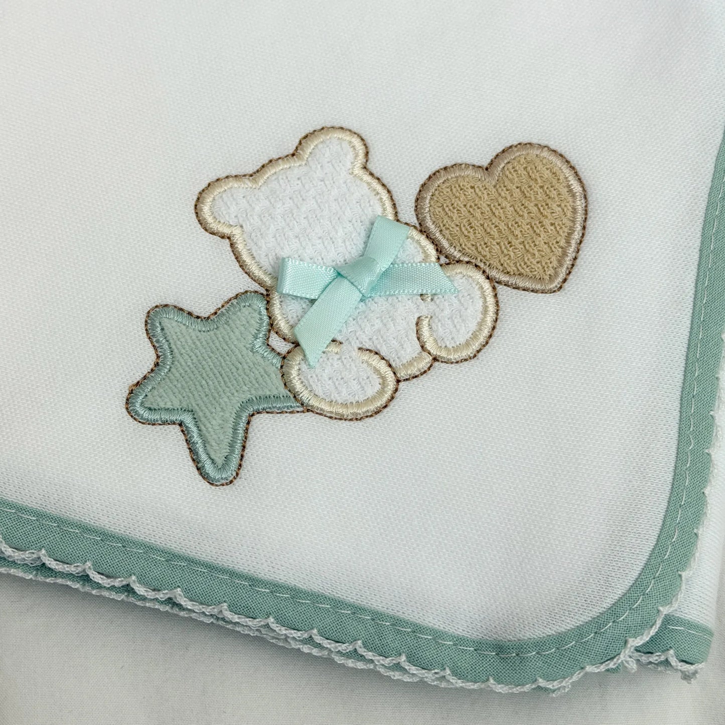 Pormenor de fralda com motivo ursinho entre estrela e coração verde