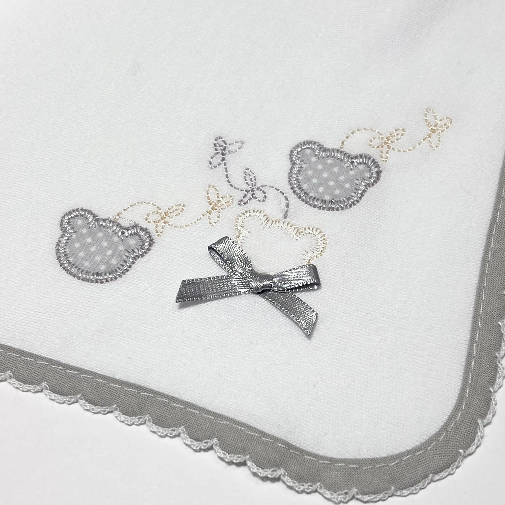 Pormenor de fralda com motivo ursinhos com pintas cinza