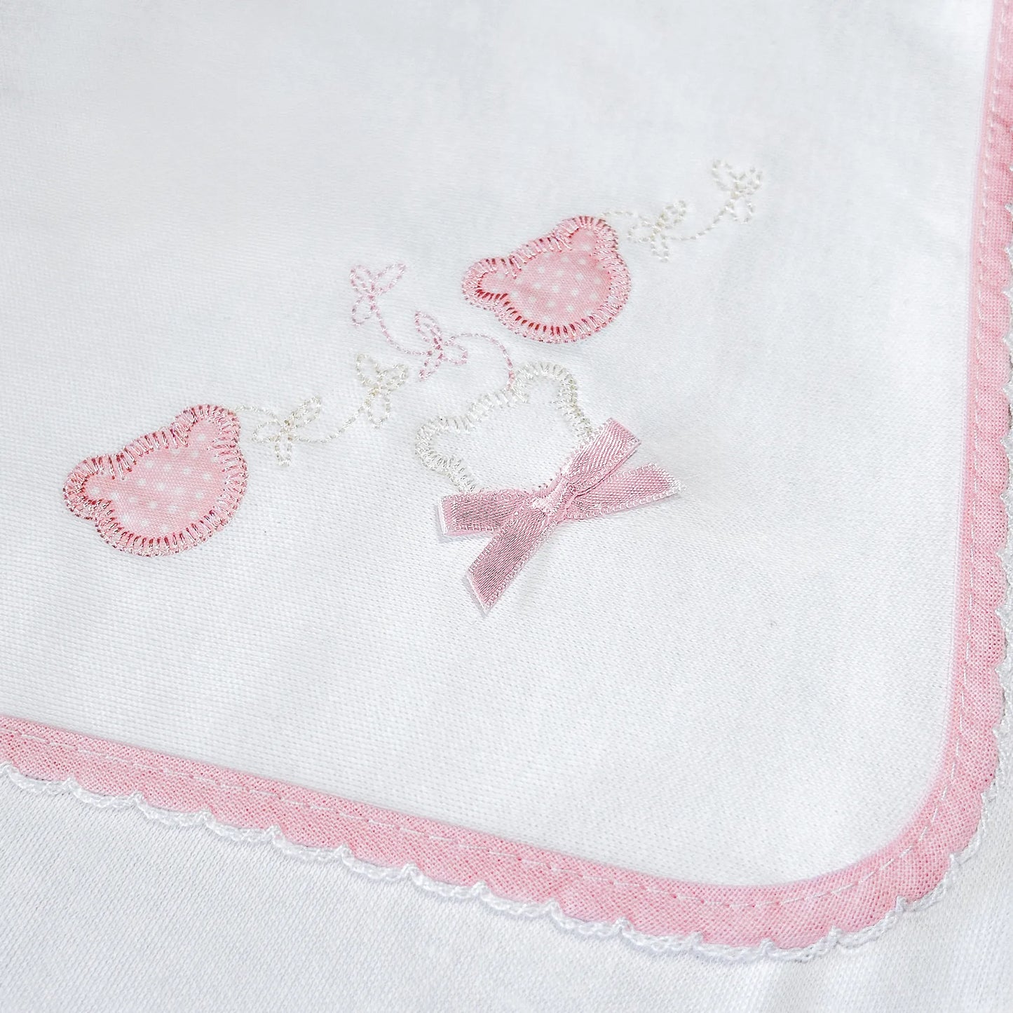 Pormenor de fralda com motivo ursinhos com pintas rosa