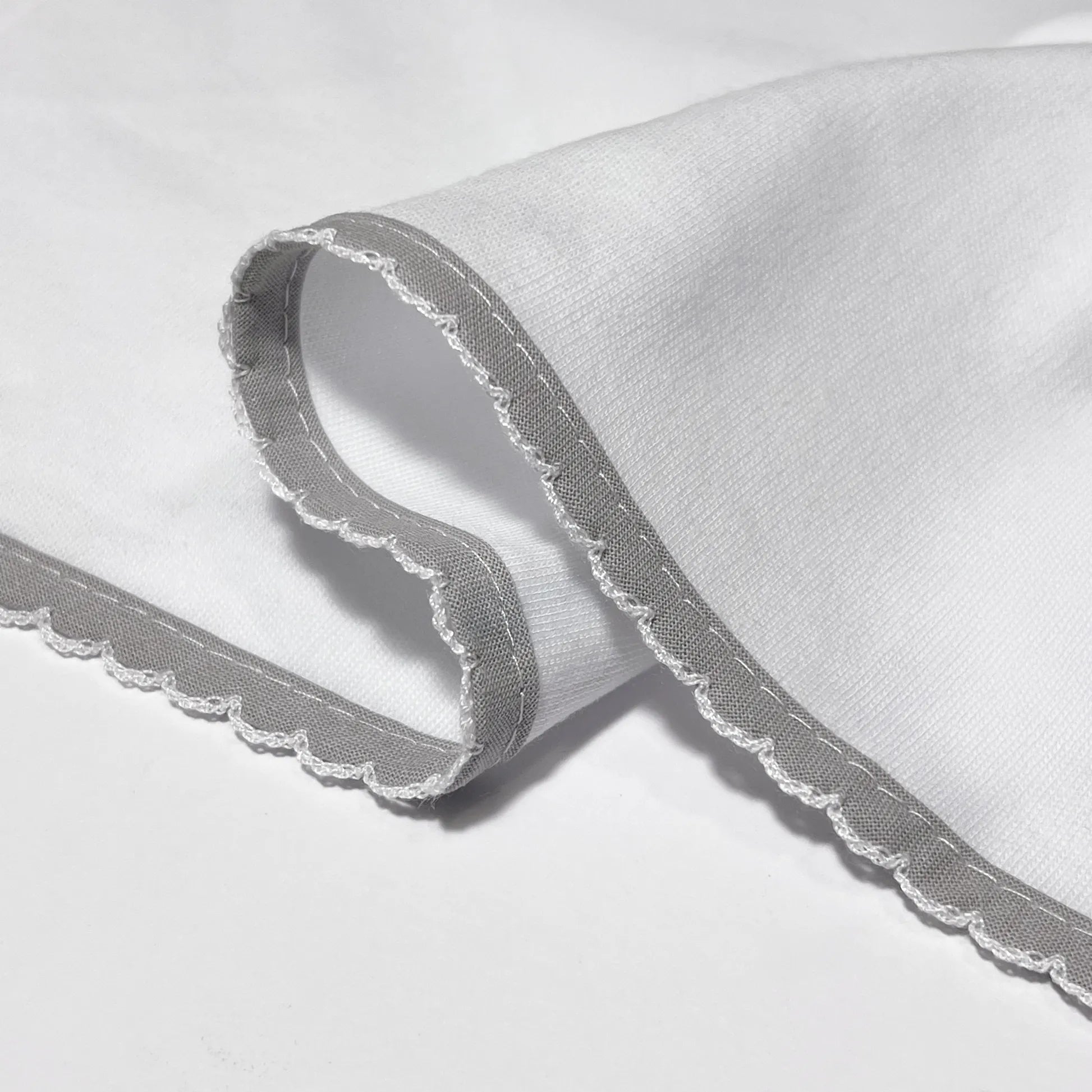 Pormenor de fralda com motivo ursinhos tricot e lacinho cinza