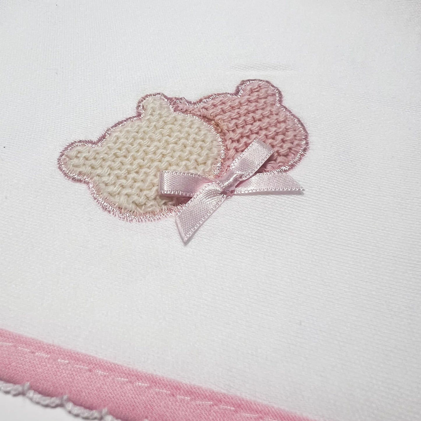 Pormenor de fralda com motivo ursinhos tricot e lacinho rosa