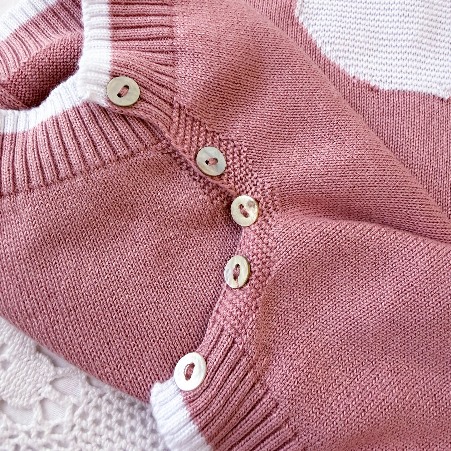 Pormenor de macacão em malha com gola Peter Pan e motivo ursinho rosa