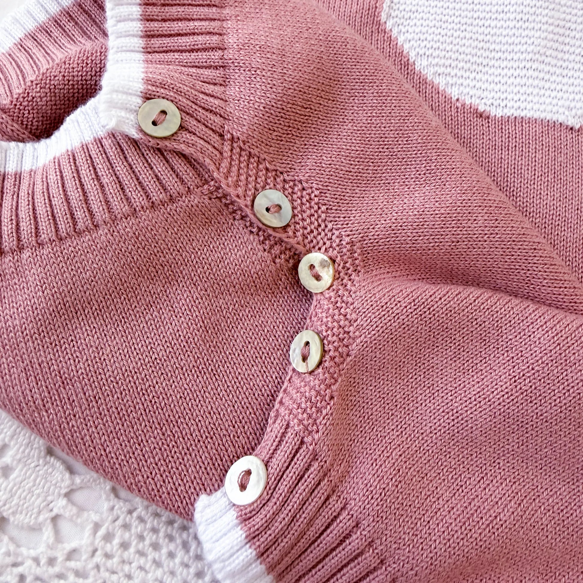 Pormenor de macacão em malha com gola Peter Pan e motivo ursinho rosa