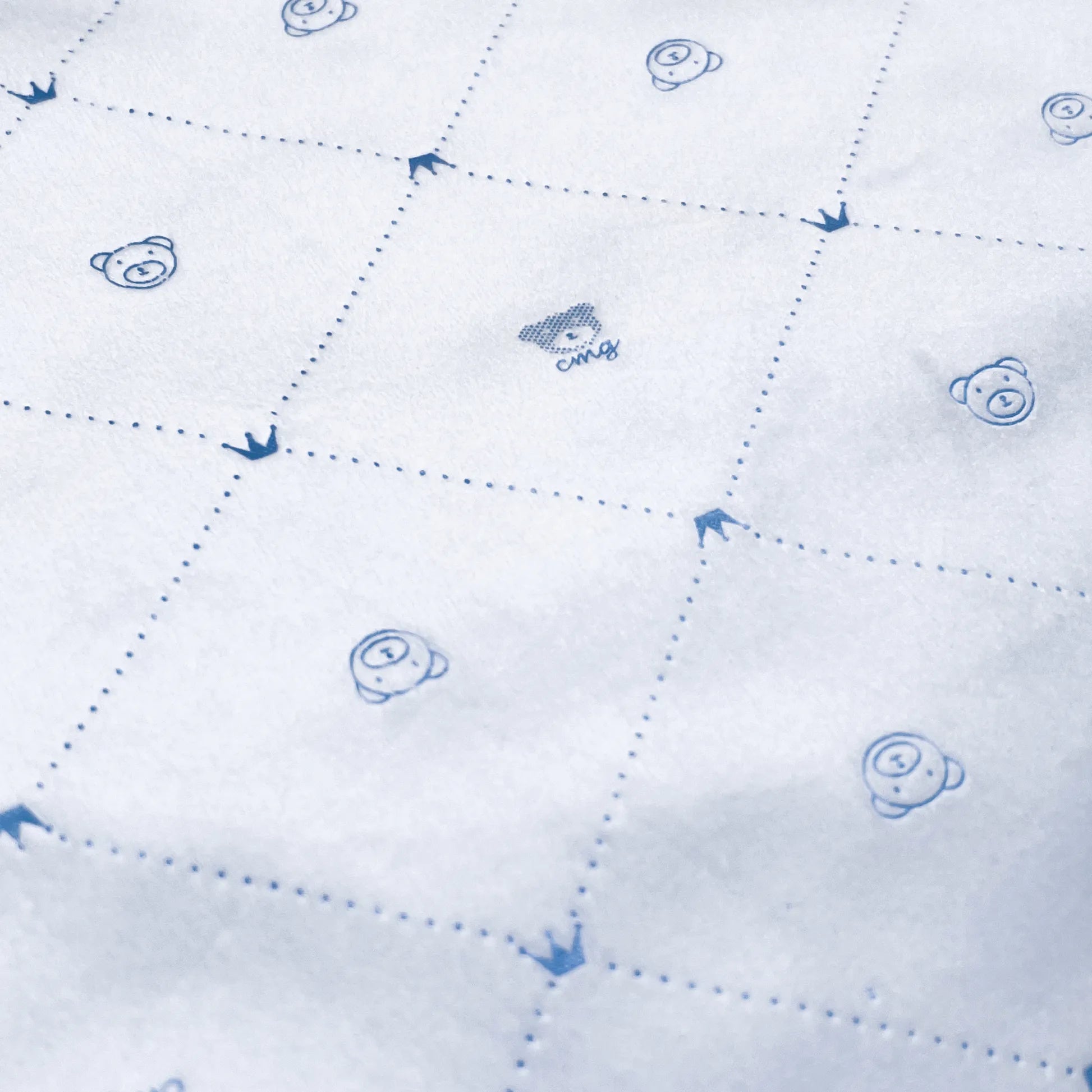 Pormenor de manta dupla face com estampado de ursinhos e losangos de um lado azul