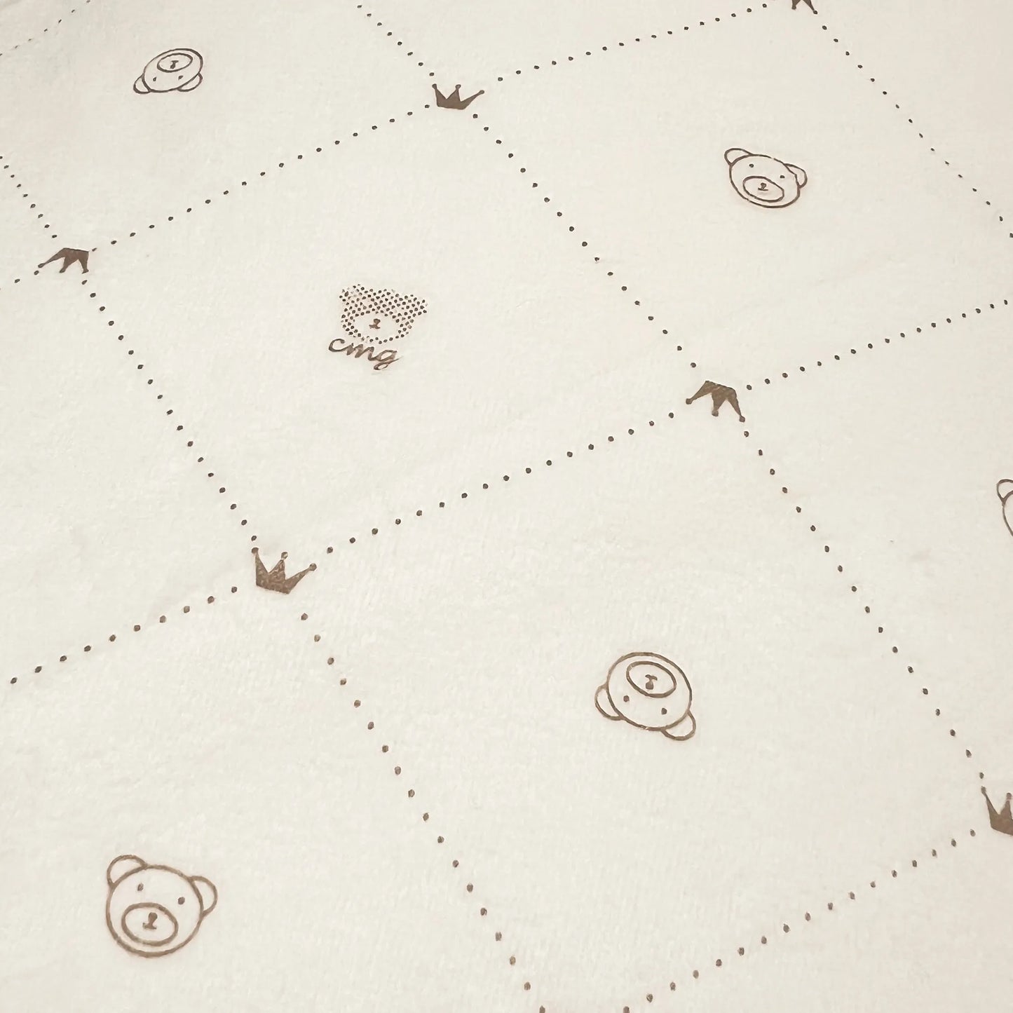 Pormenor de manta dupla face com estampado de ursinhos e losangos de um lado pérola