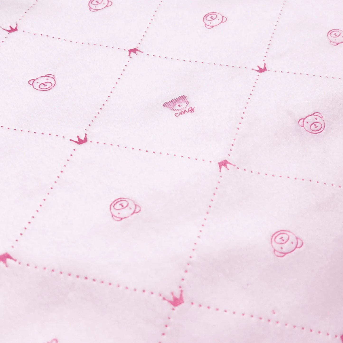 Pormenor de manta dupla face com estampado de ursinhos e losangos de um lado rosa