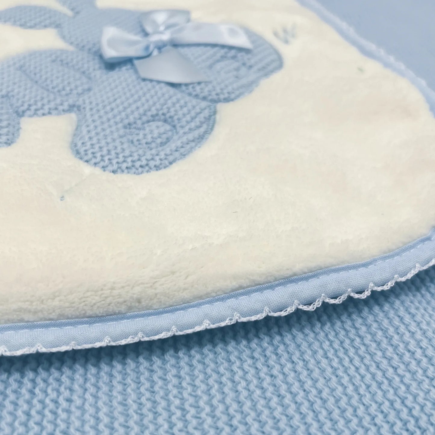 Pormenor de manta com motivo coelhos tricot com laço azul