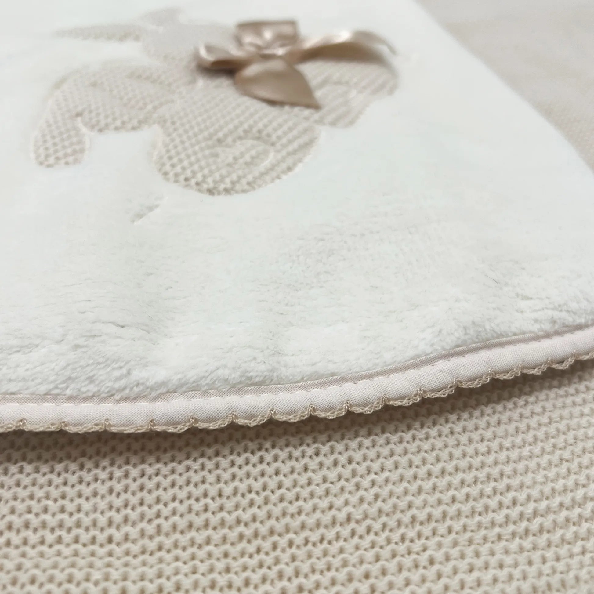 Pormenor de manta com motivo coelhos tricot com laço bege