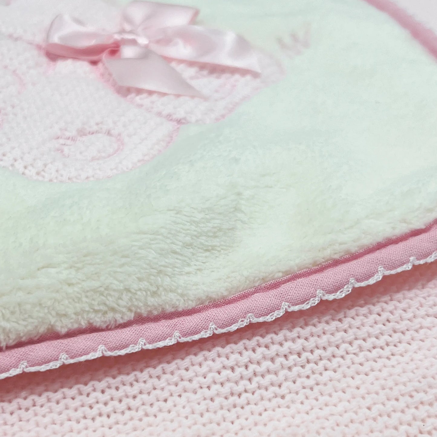 Pormenor de manta com motivo coelhos tricot com laço rosa