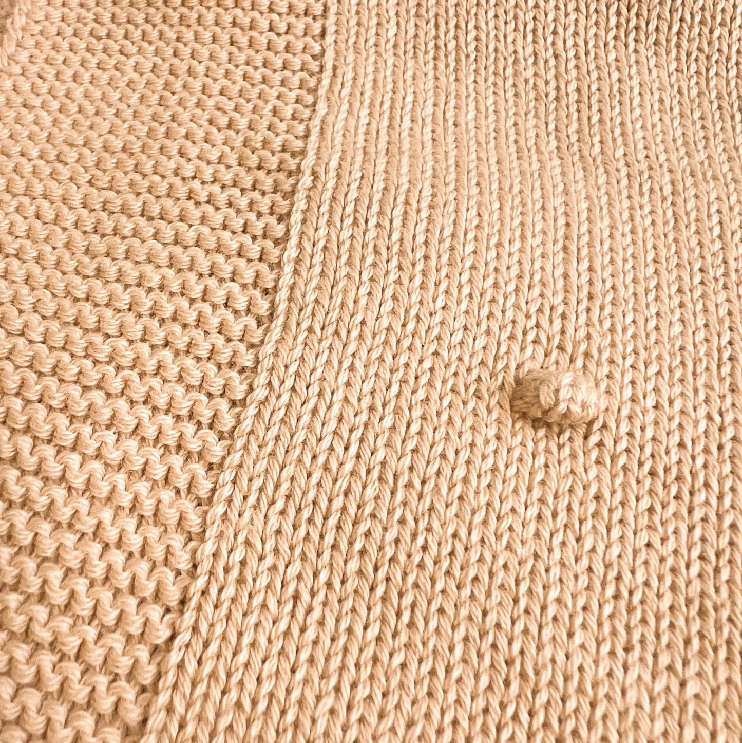 Pormenor de manta em tricot com relevo de pompons bege