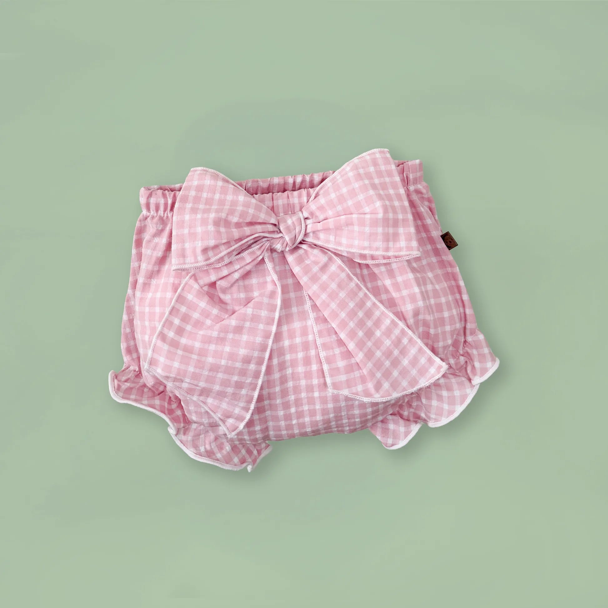 Tapa-fraldas de menina em tecido com laço na frente e folhos rosa