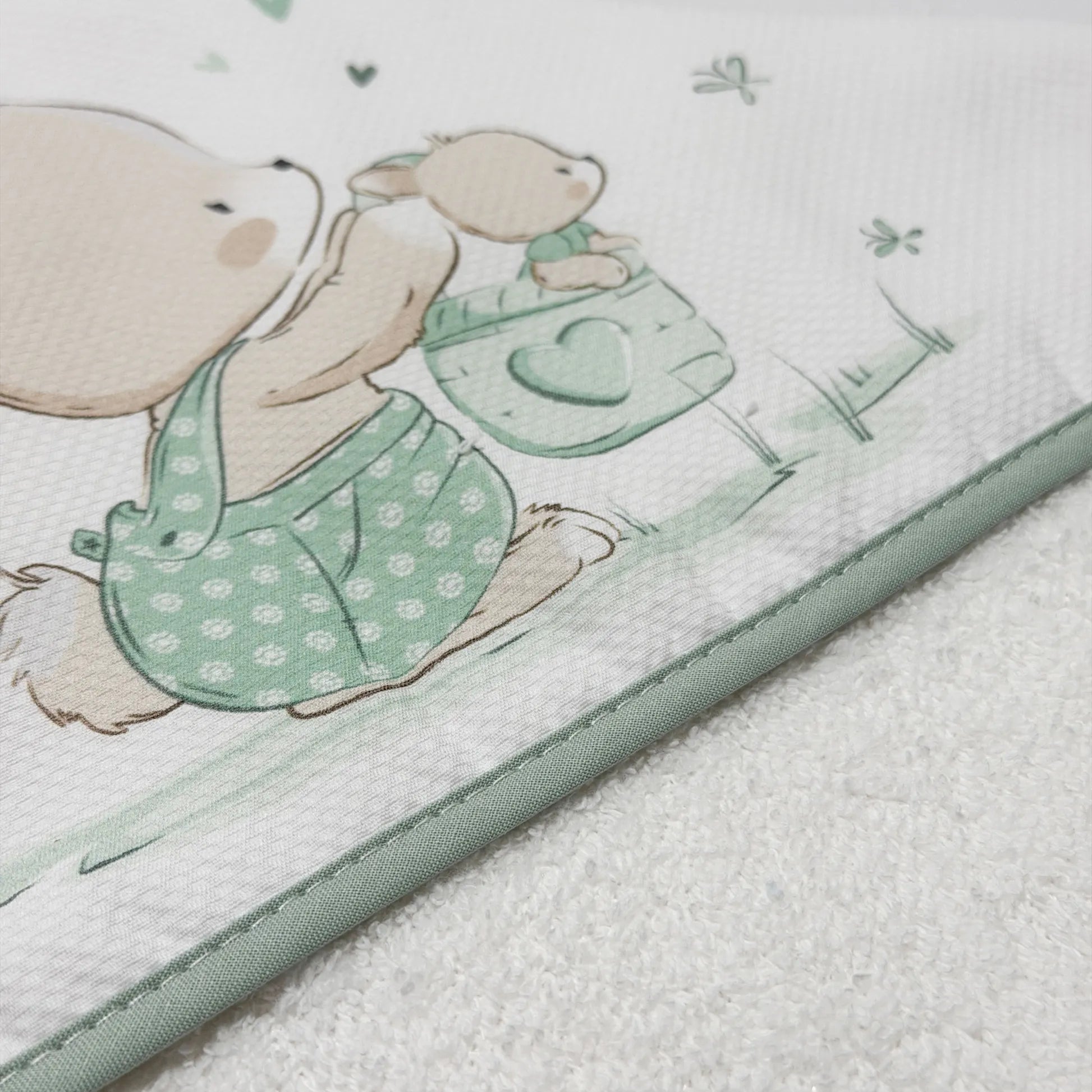 Pormenor de toalha com motivo coelhinho na cesta verde
