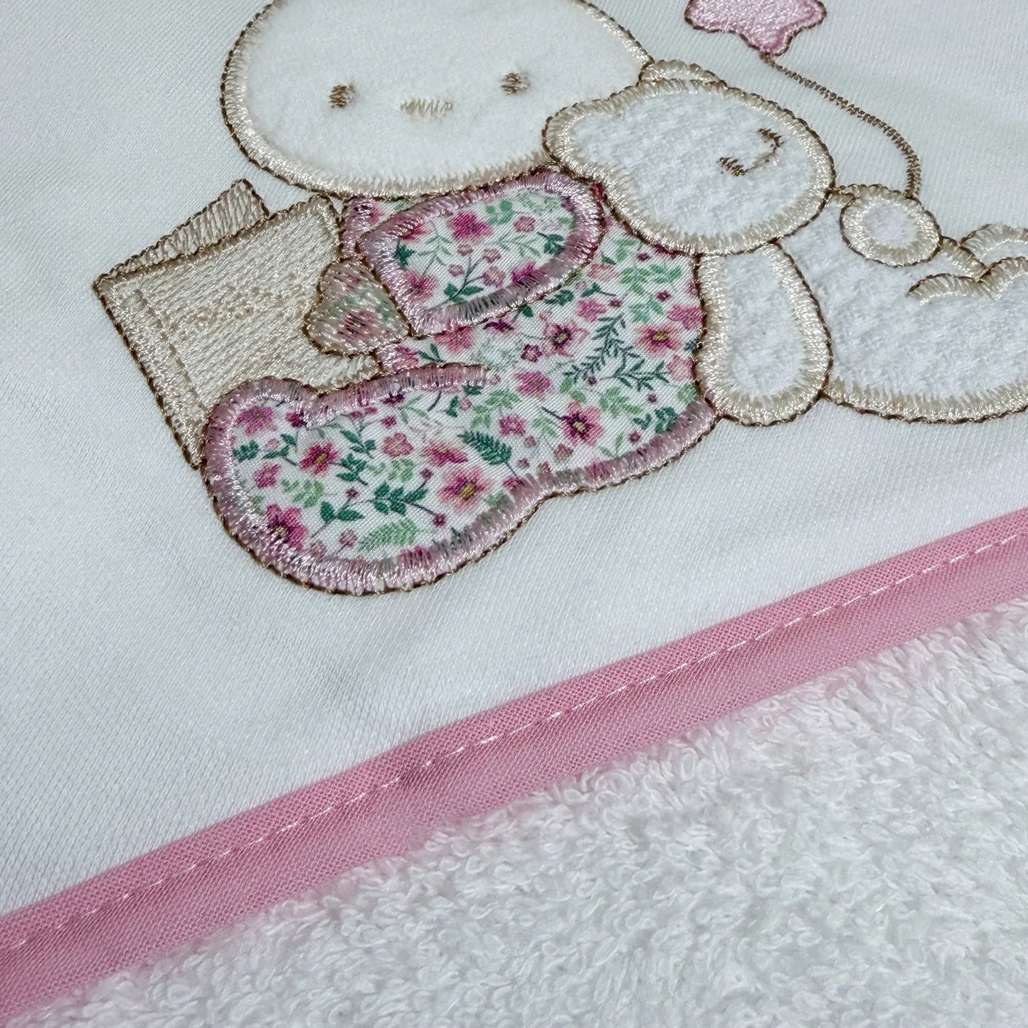 Pormenor de toalha com motivo coelhinho e ursinho com livro rosa