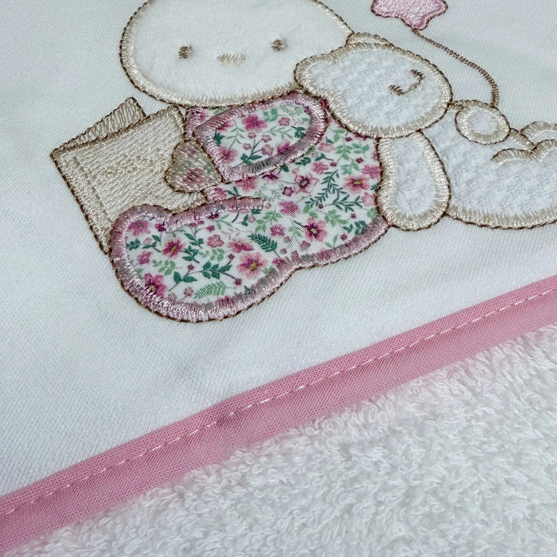 Pormenor de toalha com motivo coelhinho e ursinho com livro rosa