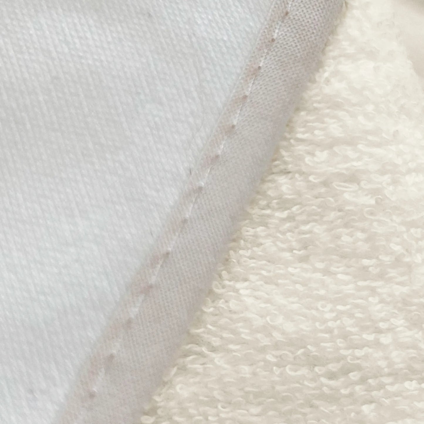 Pormenor de toalha com motivo coelhos tricot com laço bege