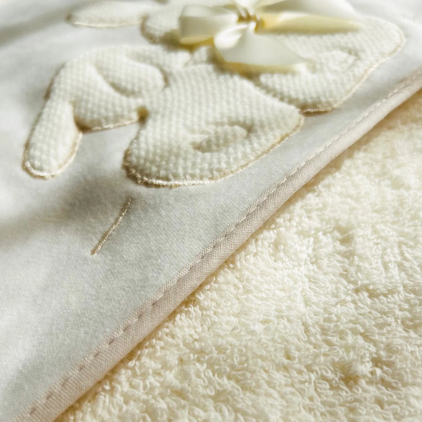 Pormenor de toalha com motivo coelhos tricot com laço pérola