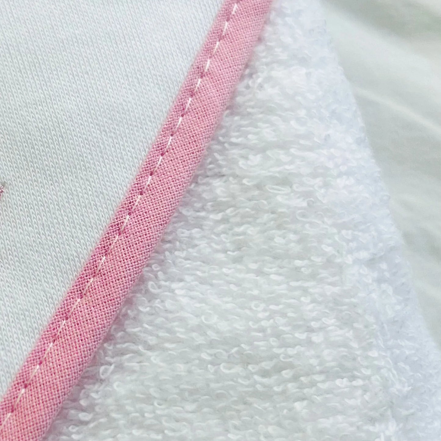 Pormenor de toalha com motivo coelhos tricot com laço rosa