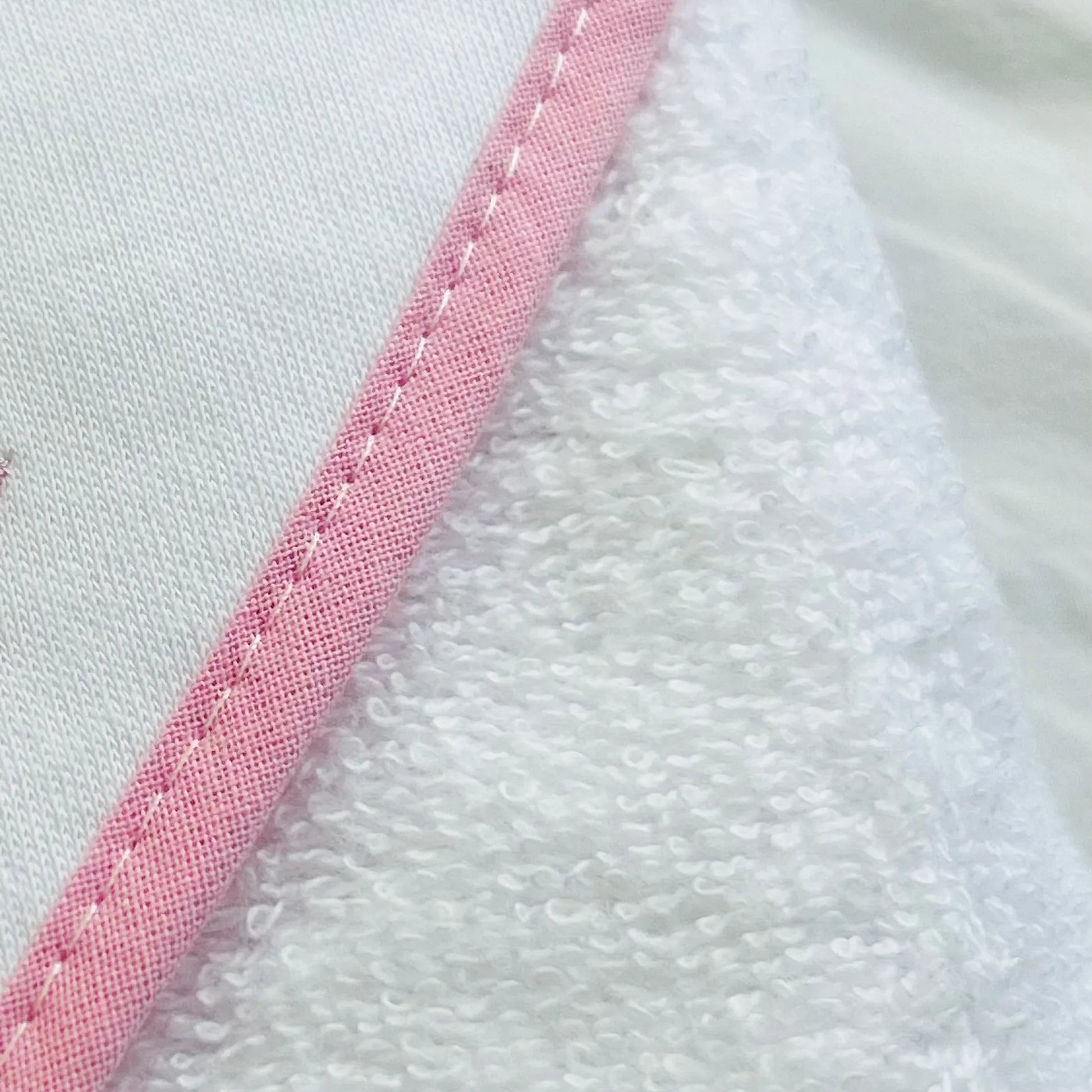 Pormenor de toalha com motivo coelhos tricot com laço rosa