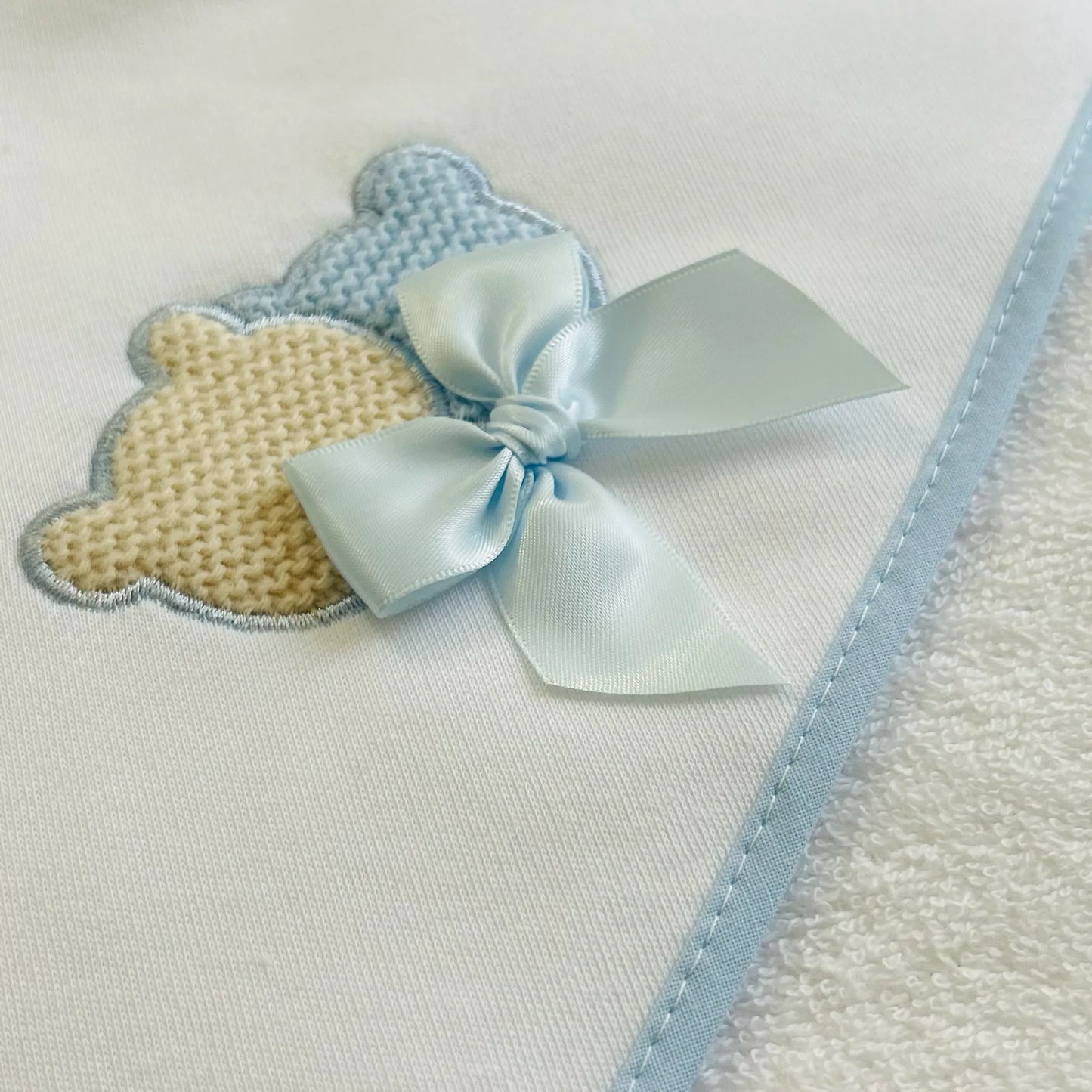 Pormenor de toalha com motivo ursinhos tricot e laço azul