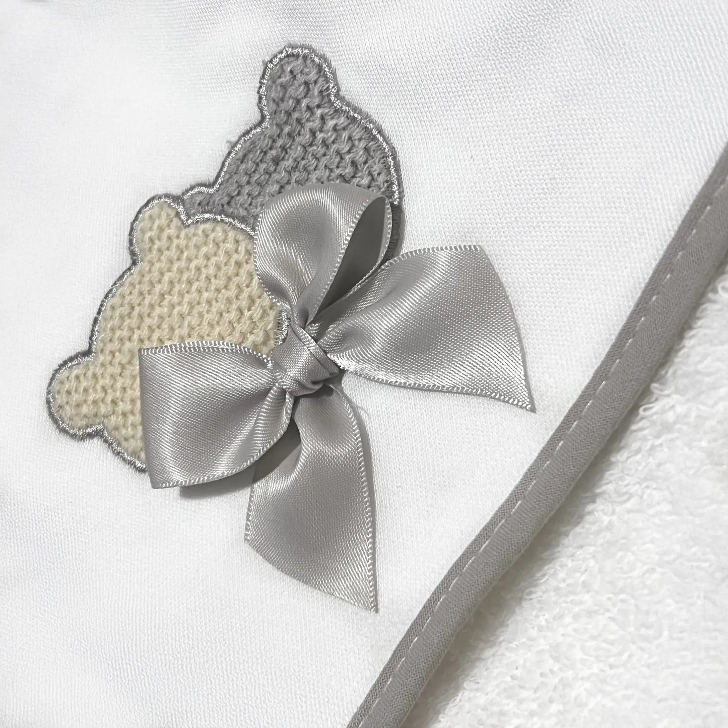 Pormenor de toalha com motivo ursinhos tricot e laço cinza