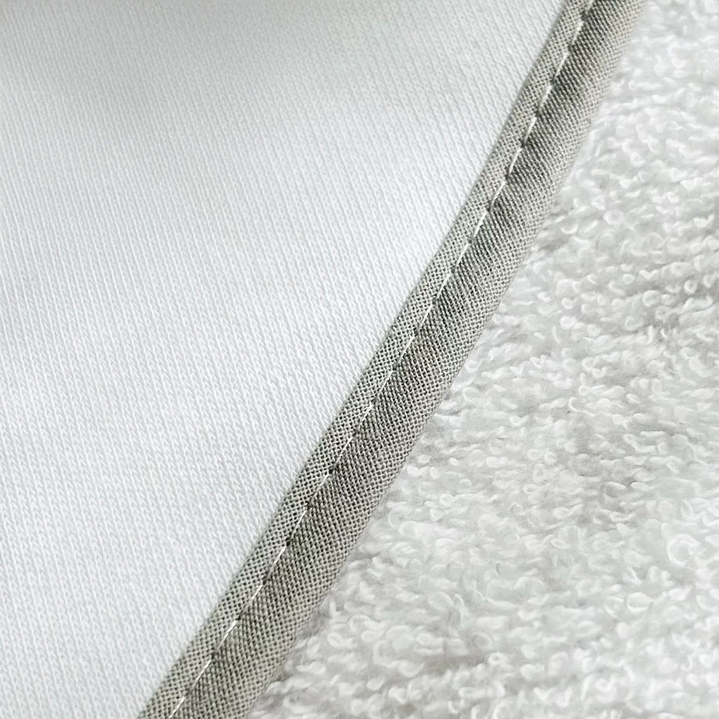 Pormenor de toalha com motivo ursinhos tricot e laço cinza