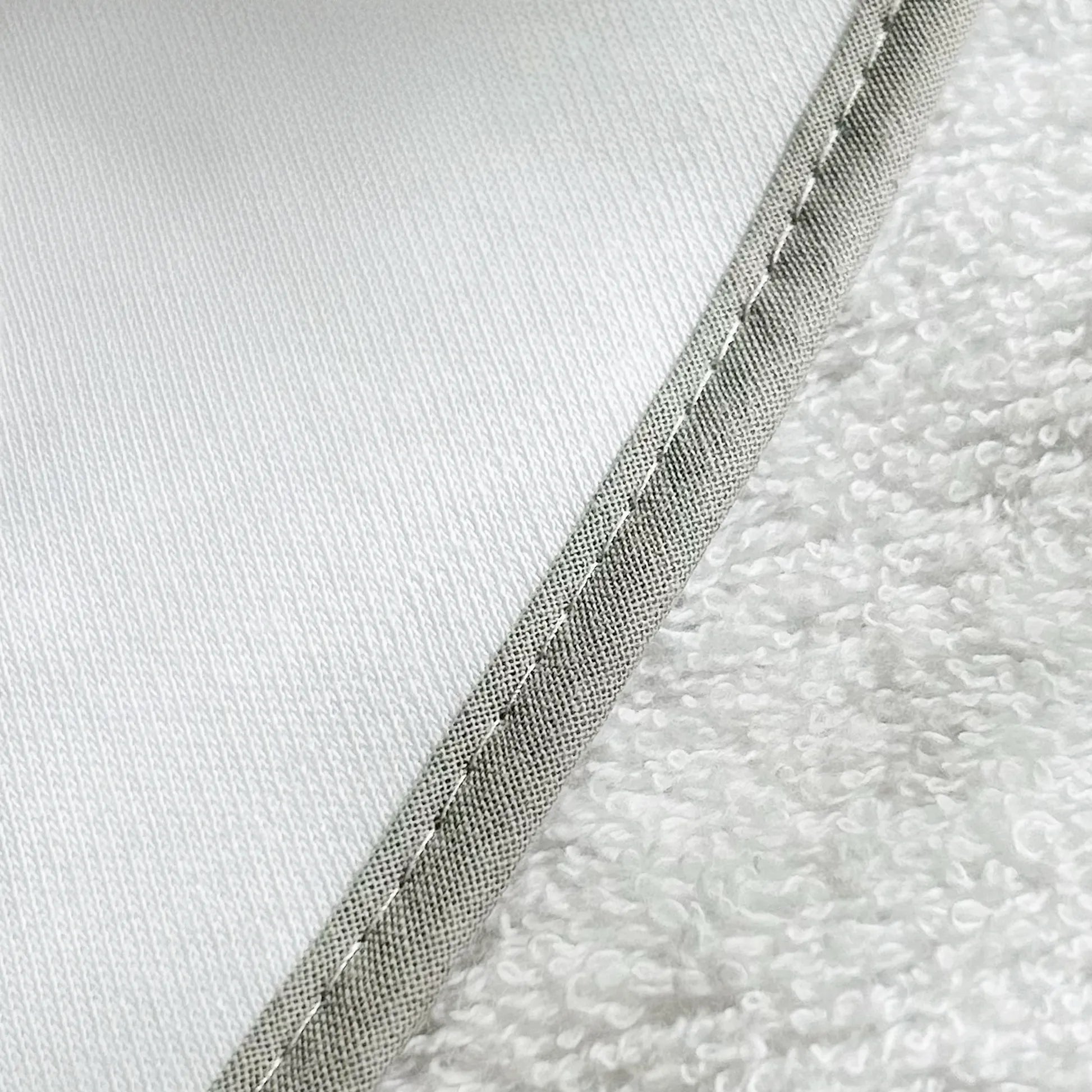 Pormenor de toalha com motivo ursinhos tricot e laço cinza