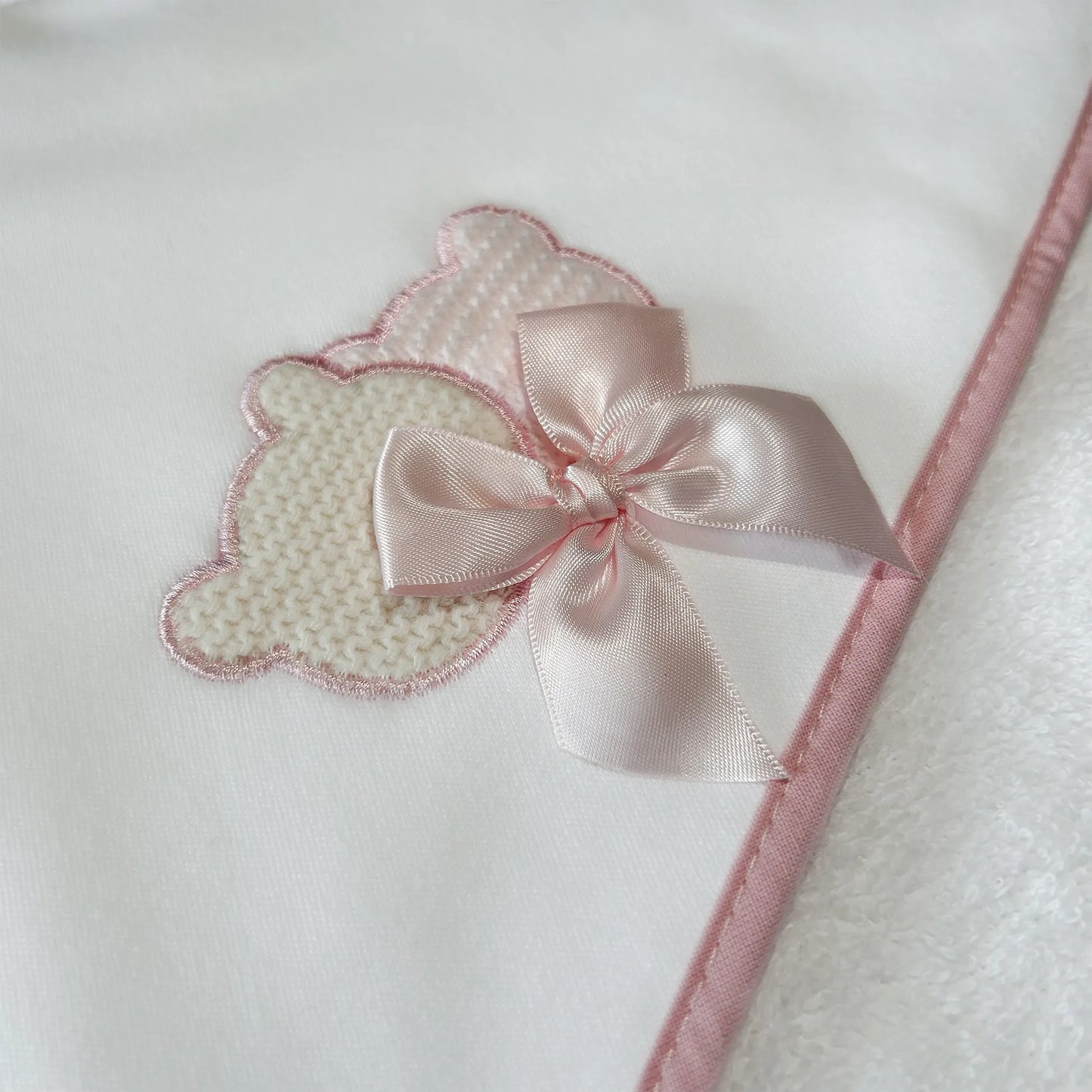 Pormenor de toalha com motivo ursinhos tricot e laço rosa