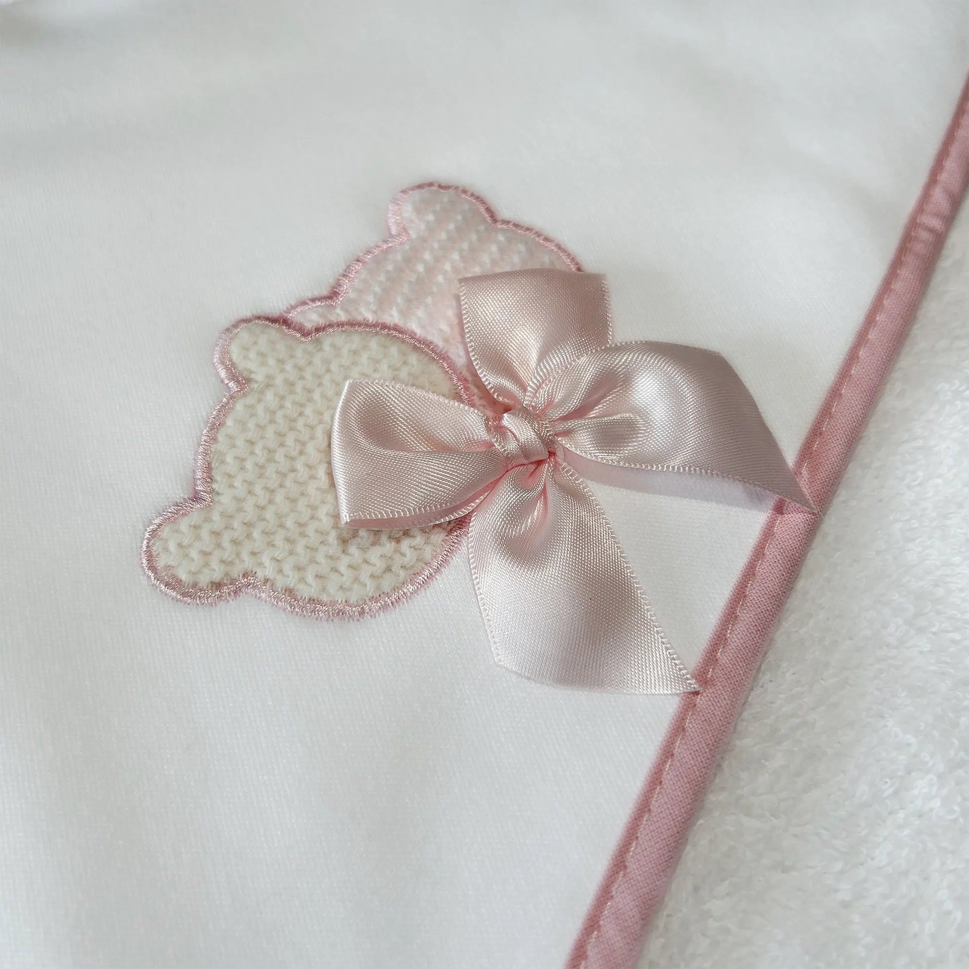 Pormenor de toalha com motivo ursinhos tricot e laço rosa