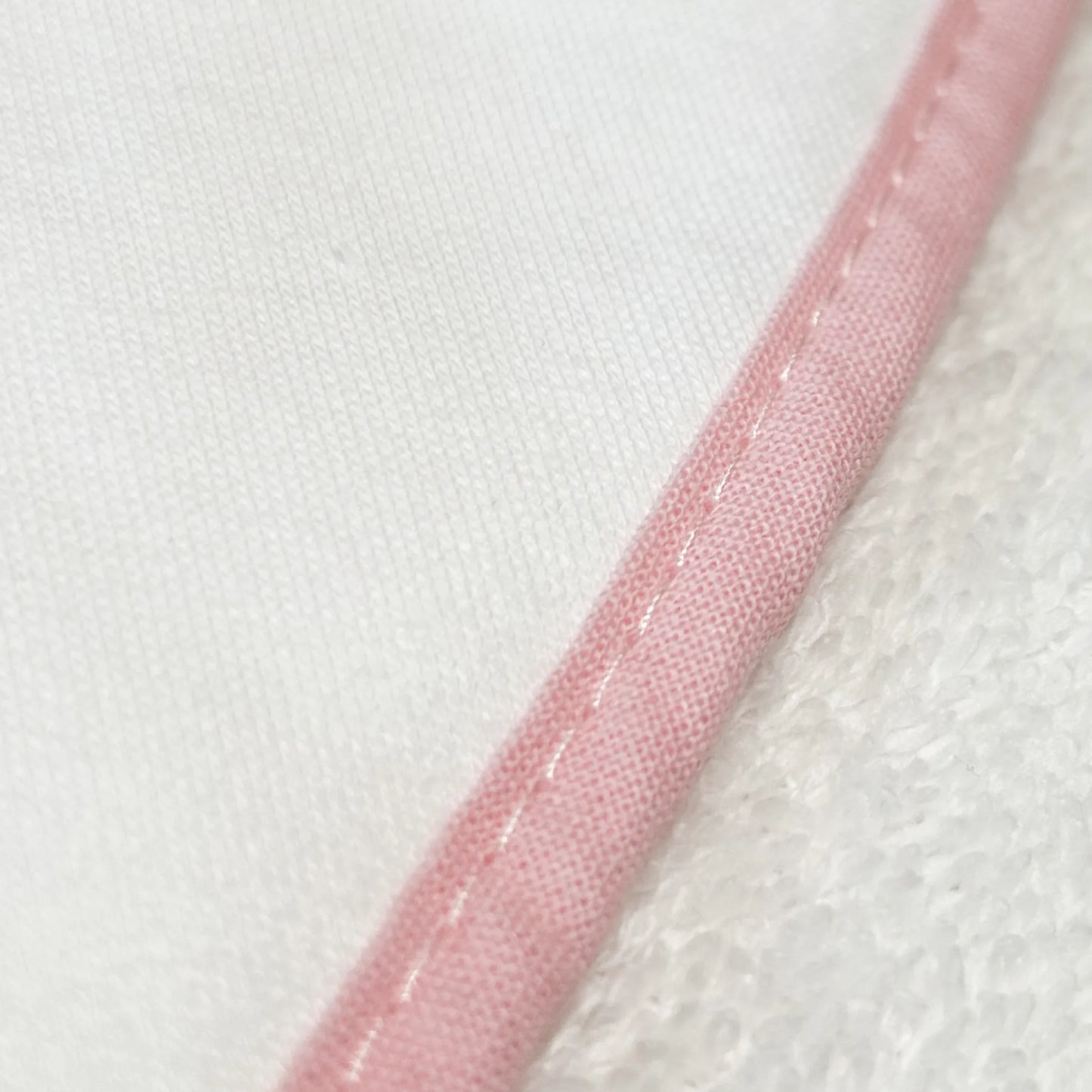 Pormenor de toalha com motivo ursinhos tricot e laço rosa