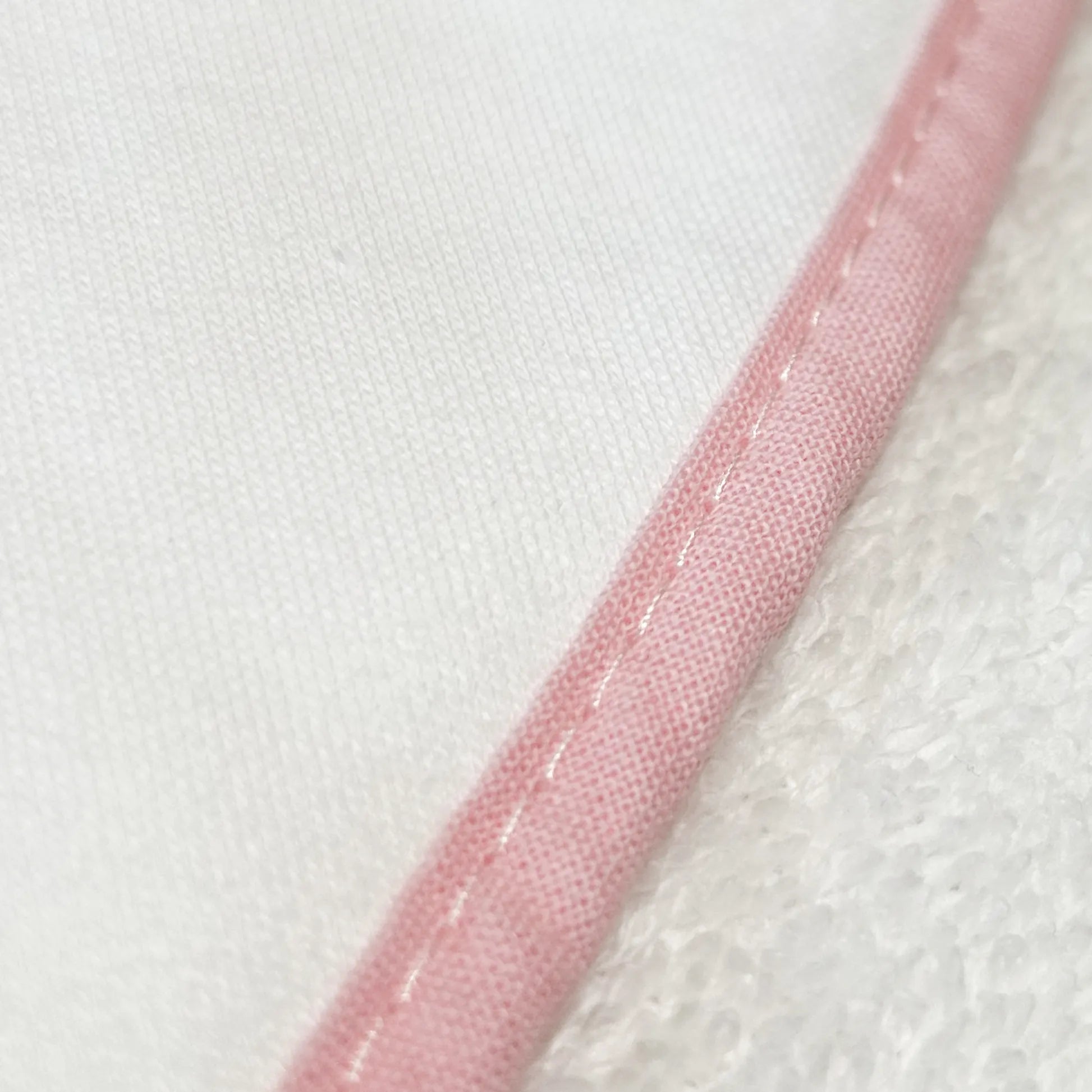 Pormenor de toalha com motivo ursinhos tricot e laço rosa