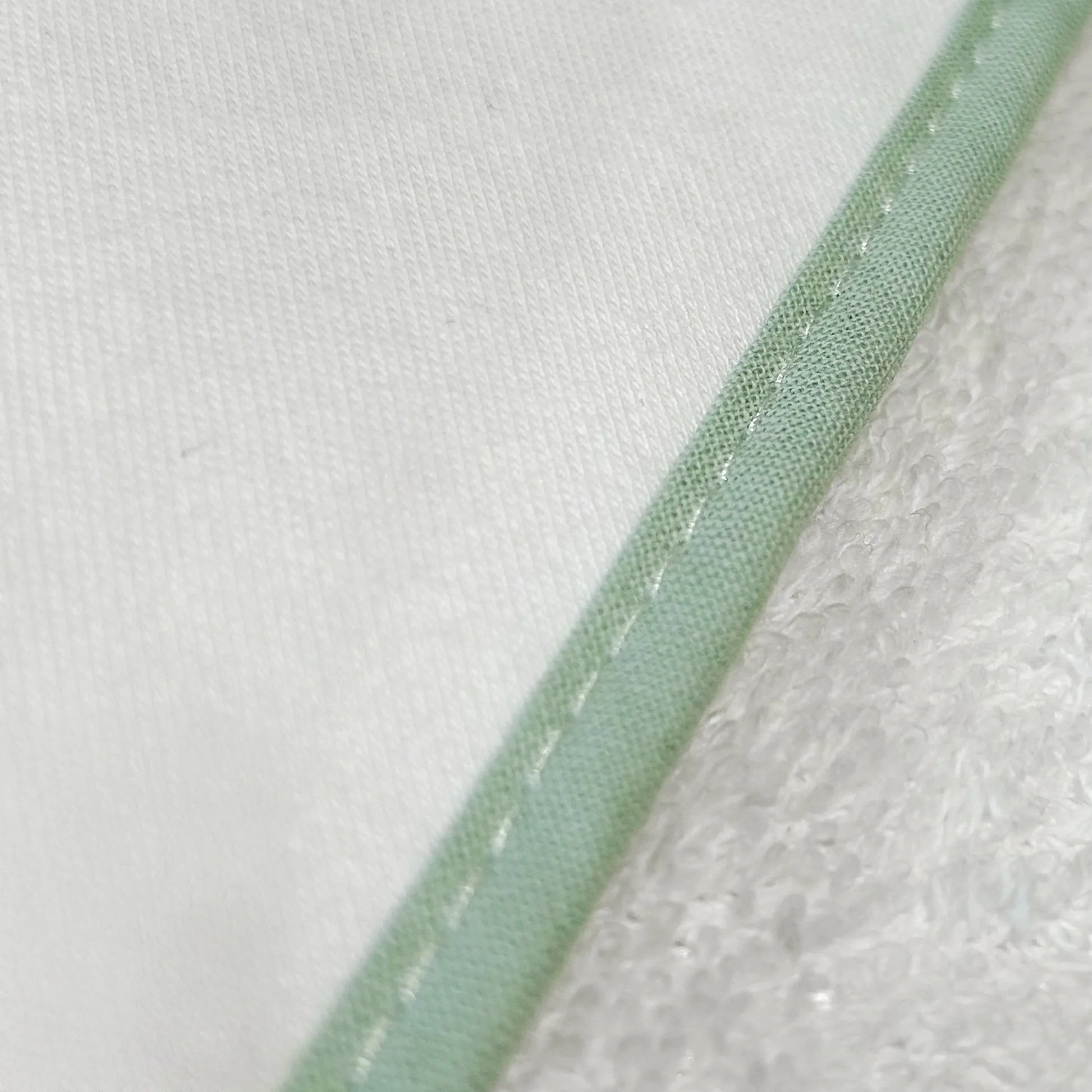 Pormenor de toalha com motivo ursinhos tricot e laço verde